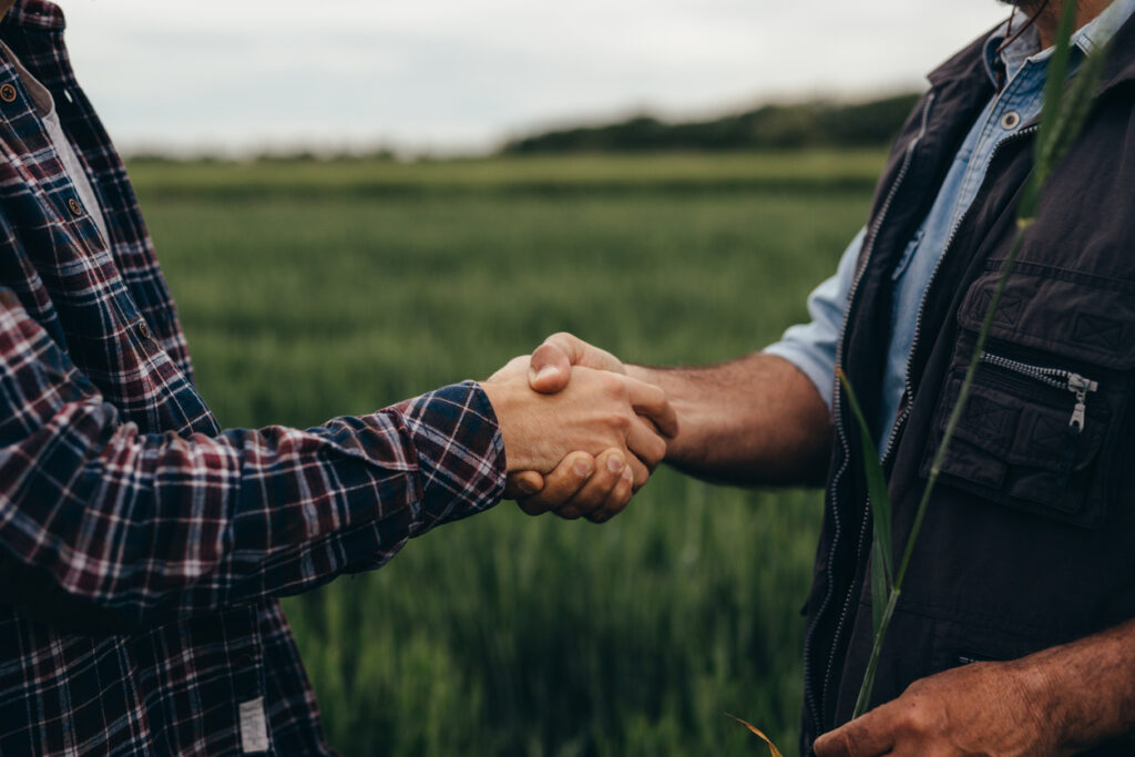 close up of two man handshake on field