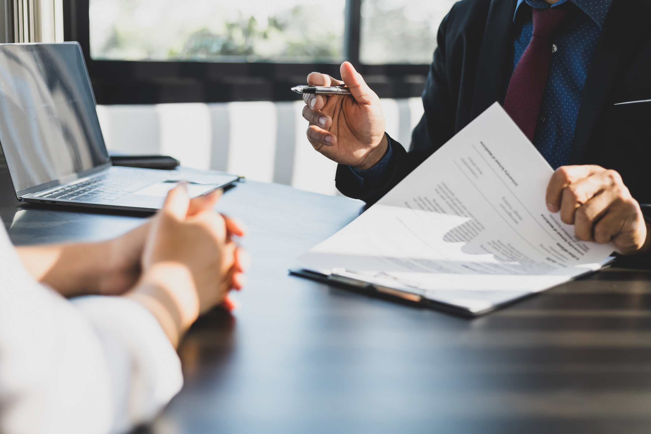 A closeup shot of a business person explaining a contract to another business person. They are discussing flexible distribution management.
